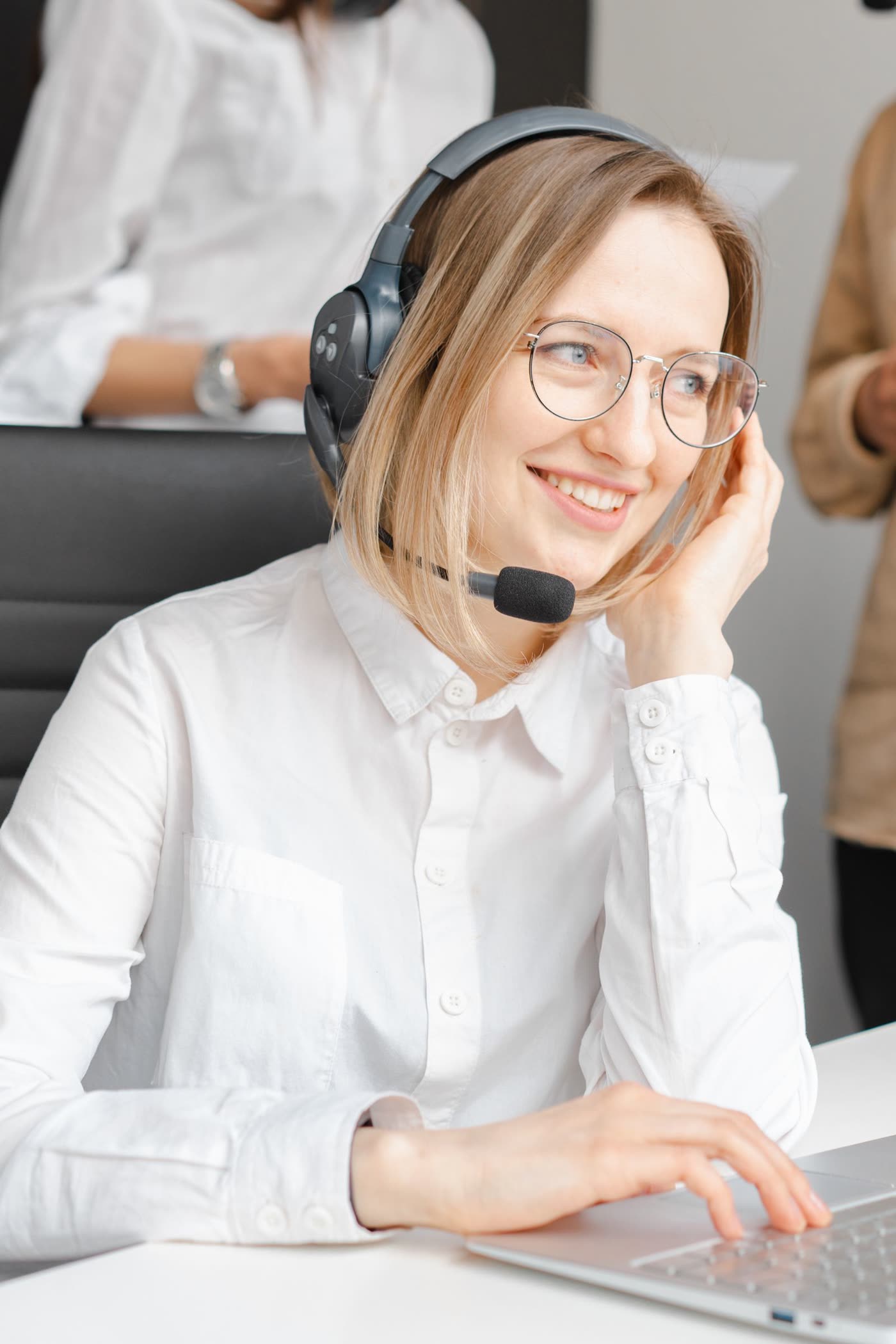 A customer-service representative wearing a headset, smiling during a call